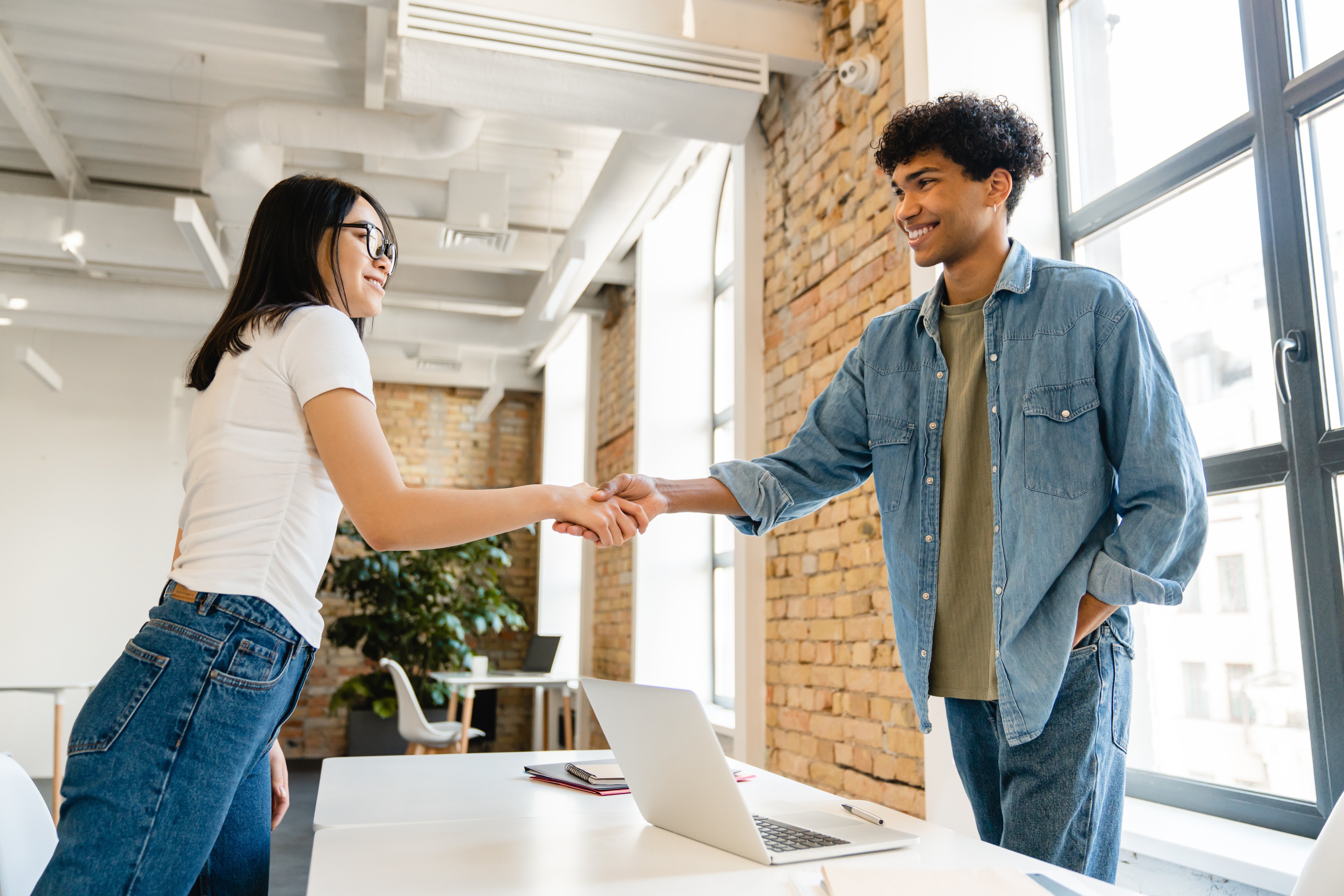 cooperative-young-colleagues-shaking-hands-at-work-2023-11-27-04-59-03-utc
